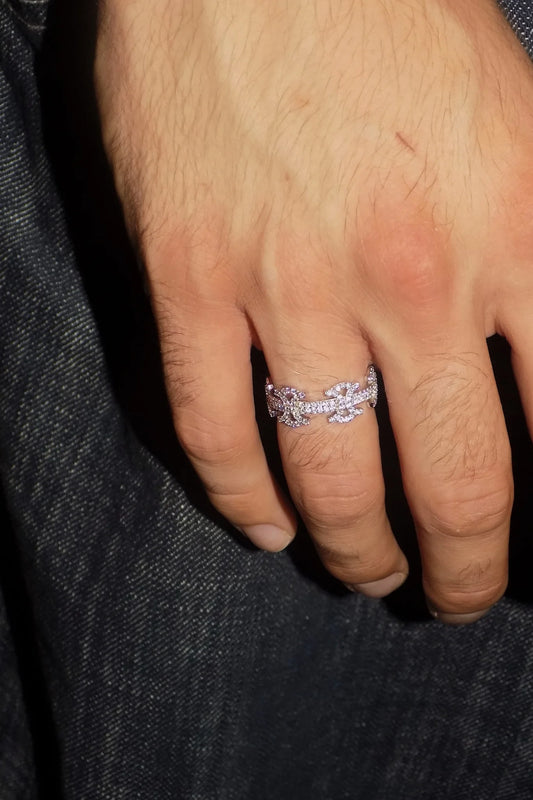 Close-up of the SYMMETRIA 925 silver ring with pavé VVS moissanite stones worn on a hand against dark denim — AETHER